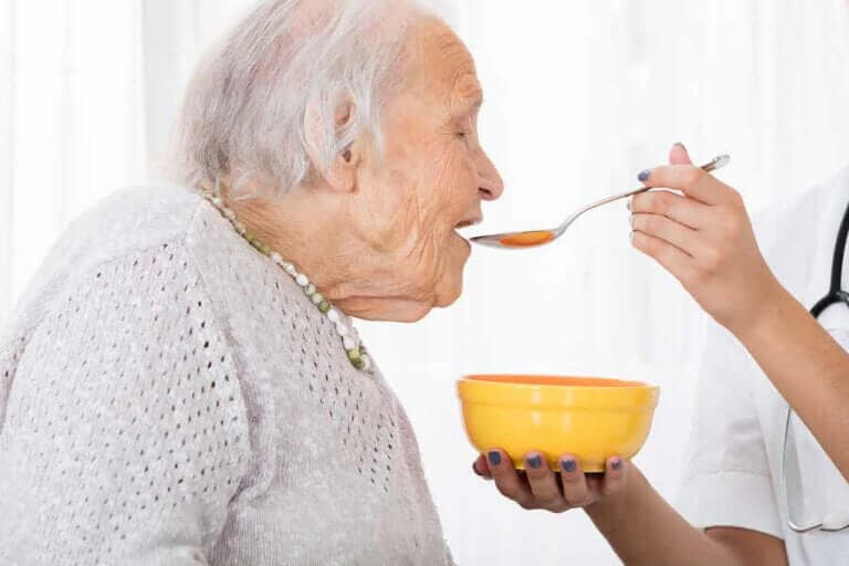 Oudere vrouw eet vloeibaar voedsel