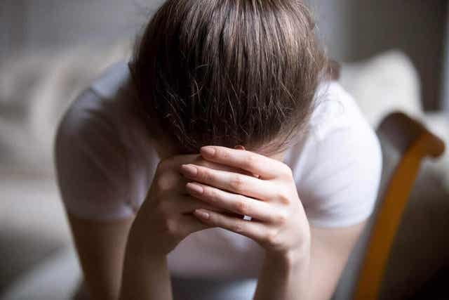 Vrouw houdt haar handen op haar hoofd