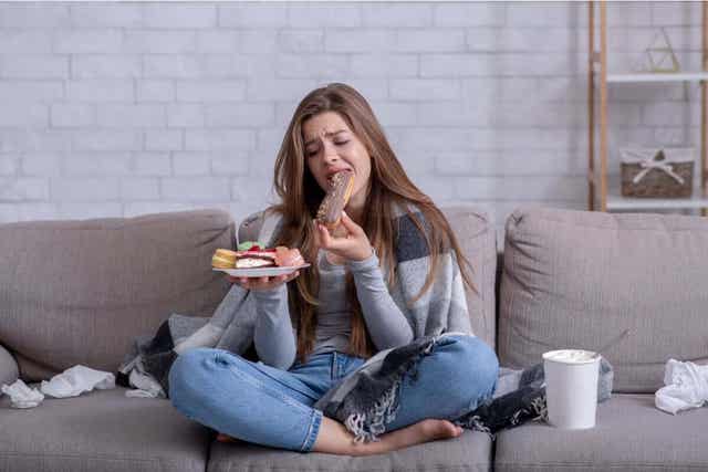 Vrouw met een bord ongezonde snacks