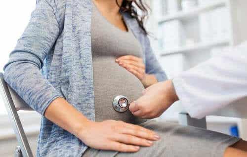 Arts met een stethoscoop op een zwangere buik