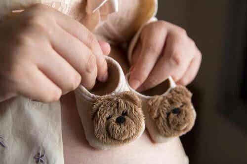 Een vrouw houdt twee kleine babyschoenen in haar handen