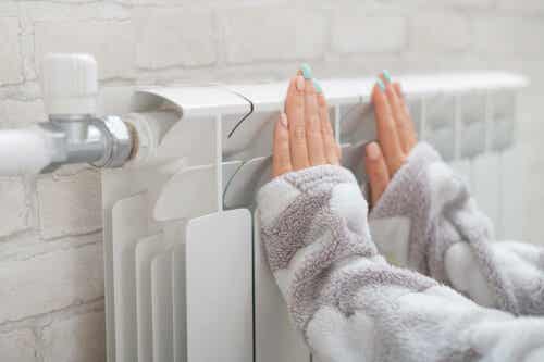 Een vrouw houdt haar handen tegen de verwarming