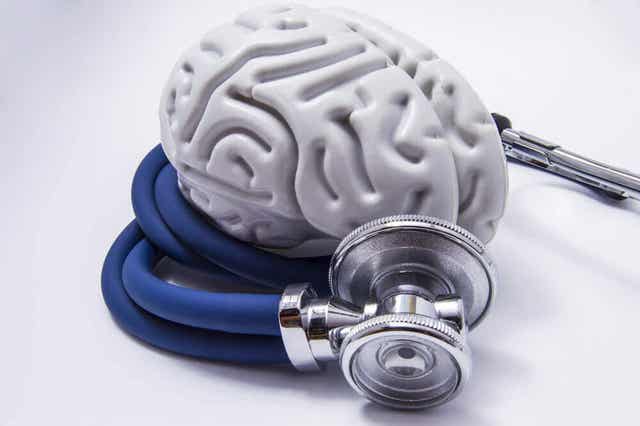 Een stethoscoop ligt om kunststof hersenen heen