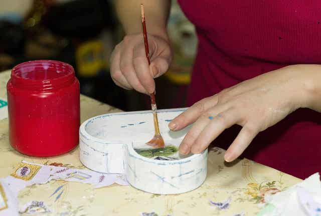 Vrouw decoreert een hartvormig doosje