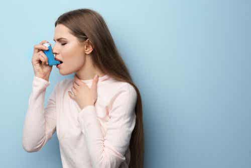 Een vrouw met astma gebruikt een inhalator