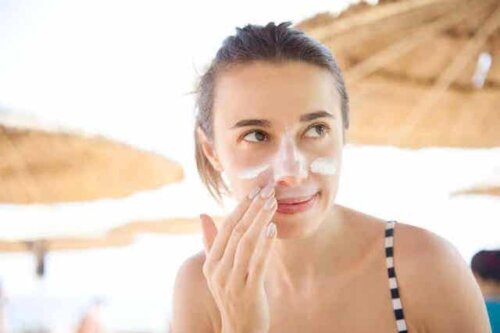 Een vrouw smeert crème op haar gezicht