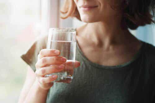 Een vrouw drinkt een glas water