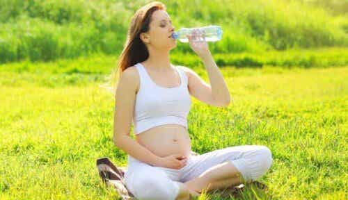 Een zwangere vrouw drinkt water