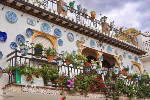 Een balkon in Andalusië bedekt met keramische bloempotten en borden