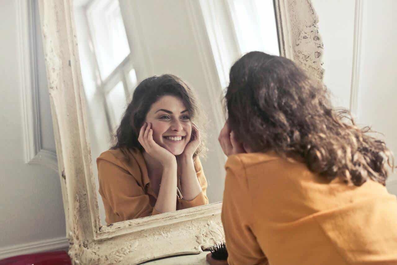 Vrouw lacht naar haar spiegelbeeld