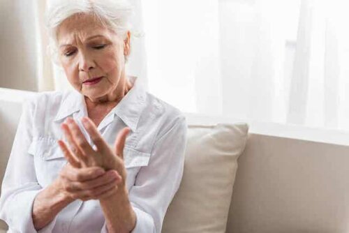 Een oudere vrouw die gewrichtspijn in haar handen heeft
